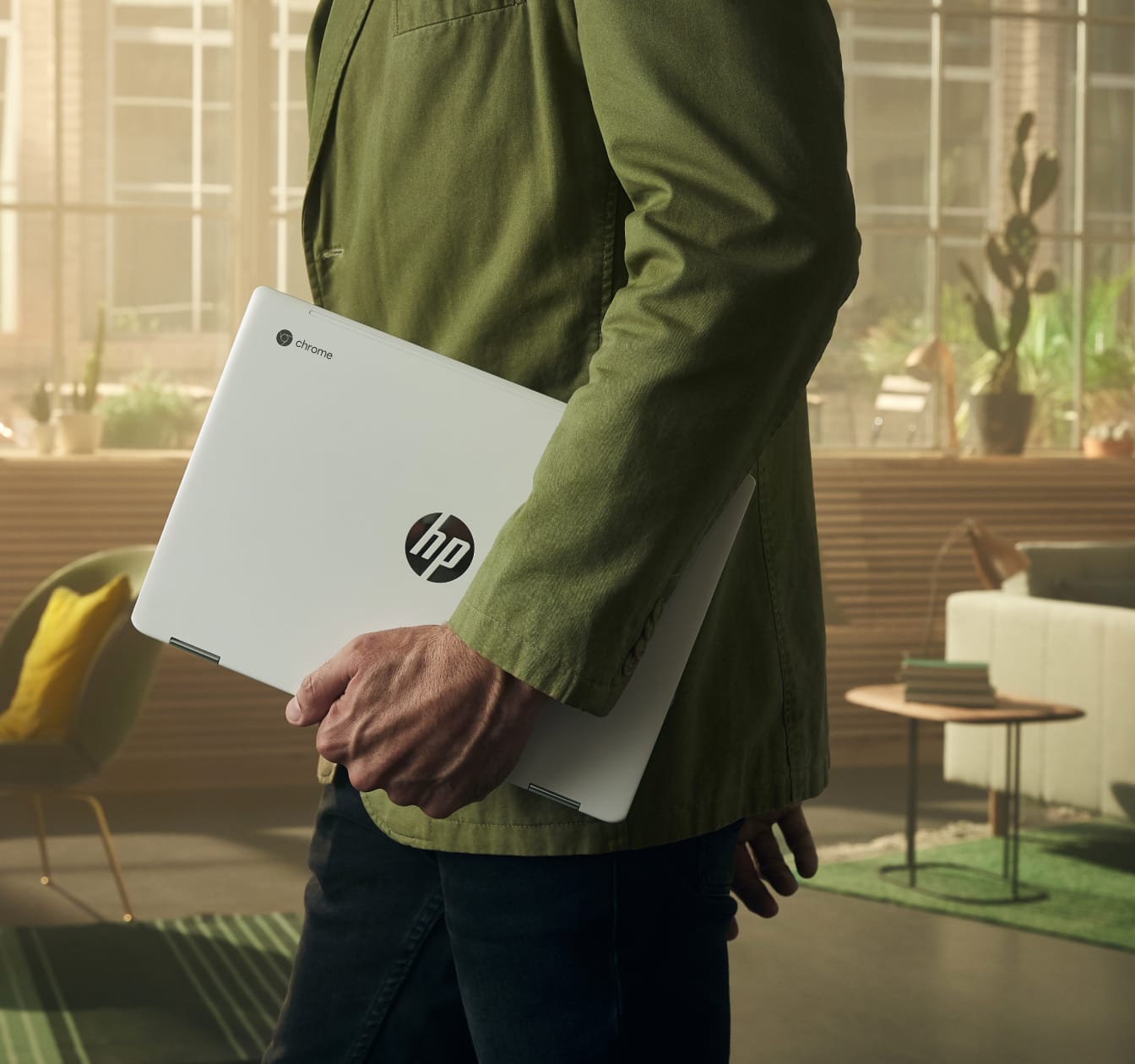 Man walking through a workspace with an HP Chromebook. The long battery life of Chromebooks make them easy to take on the go.